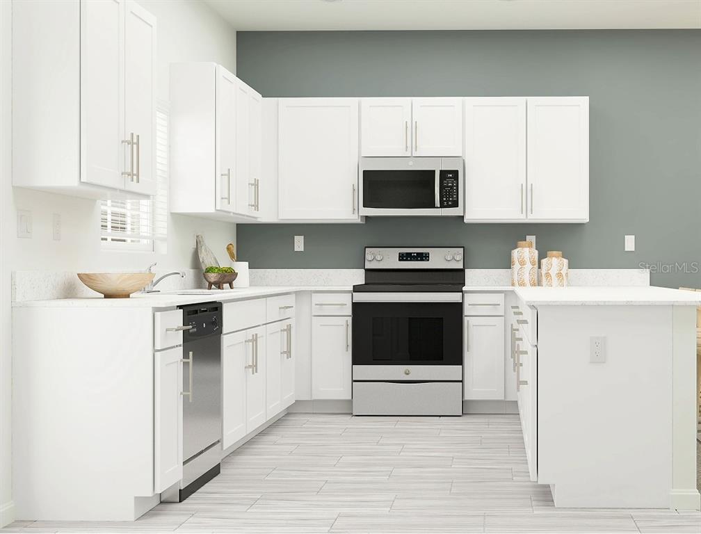 This kitchen features white cabinets, stainless steel appliances, and a gray accent wall — 3774 LONZALO WAY, NEW PORT RICHEY, FL