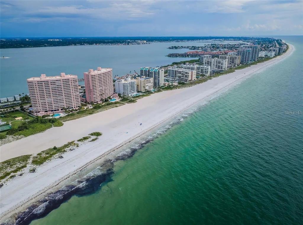 An aerial view of a sandy beach lined with high-rise residential buildings along the coast — 1310 GULF BOULEVARD UNIT 4D, CLEARWATER BEACH, FL
