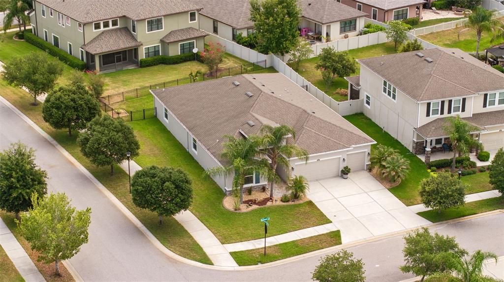 An aerial view of a single-story suburban house with a tan roof and driveway — 32373 BANNACK LANE, WESLEY CHAPEL, FL