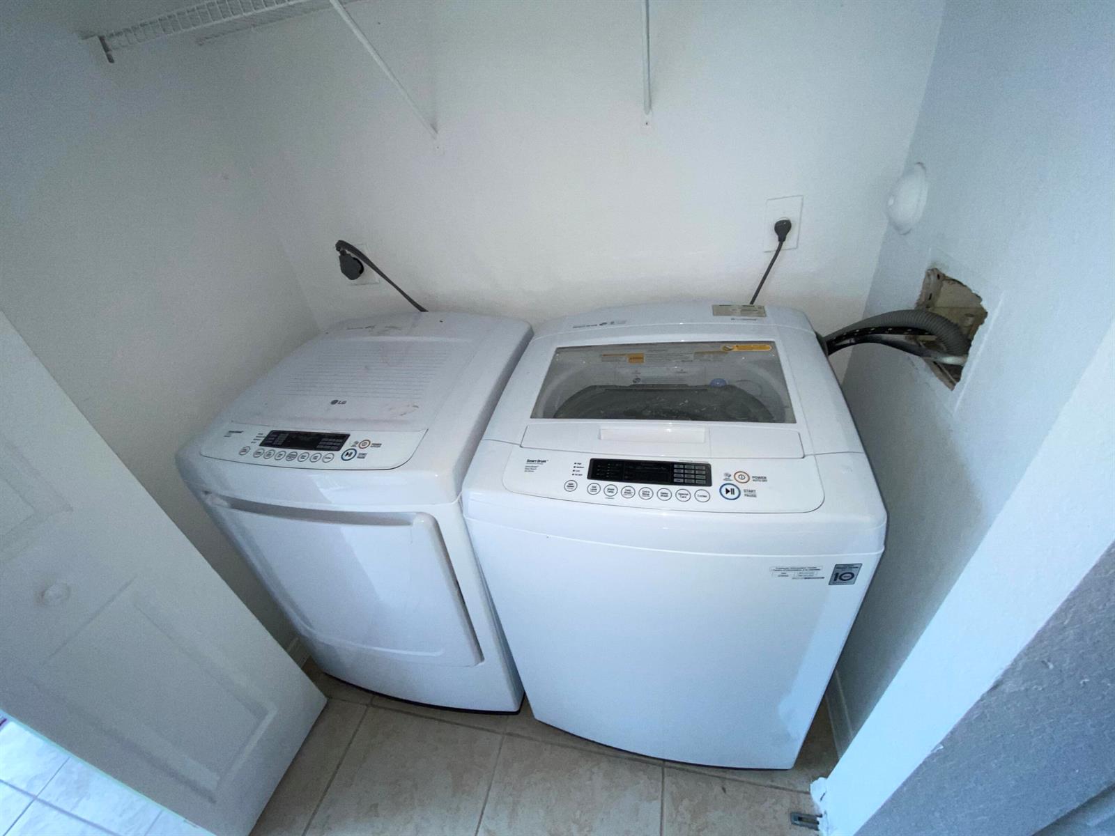 A laundry closet contains a white top-loading washing machine and a matching dryer — 618 NE 1st Street # B, Boynton Beach FL 33435, BOYNTON BEACH, FL
