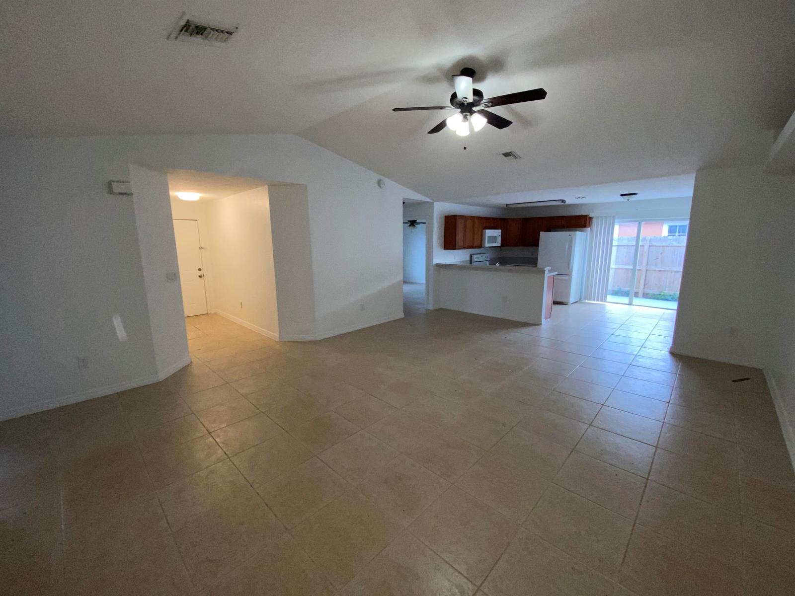 An open-concept living area features tile flooring, a ceiling fan, and an adjacent kitchen — 618 NE 1st Street # B, Boynton Beach FL 33435, BOYNTON BEACH, FL