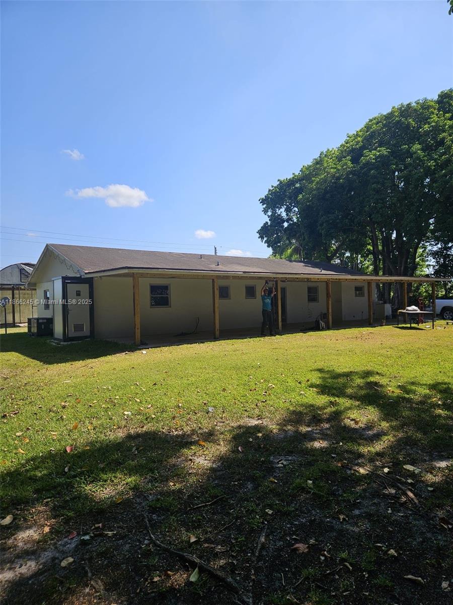 A single-story house features a long covered porch supported by wooden posts in a yard — 19230 SW 216TH ST, Miami FL 33170, MIAMI, FL
