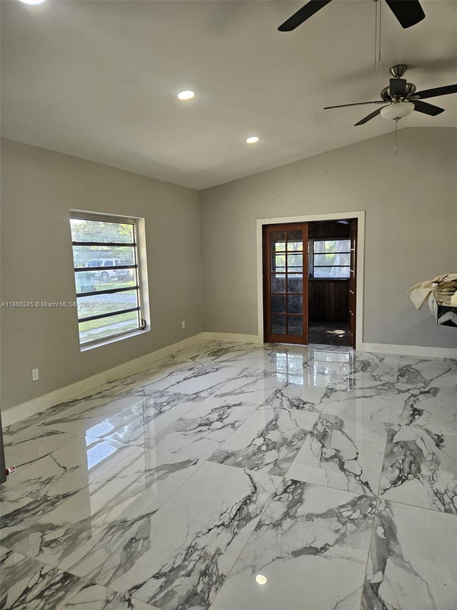 A room with gray walls, white marble-patterned tile flooring, and a wooden French door — 19230 SW 216TH ST, Miami FL 33170, MIAMI, FL