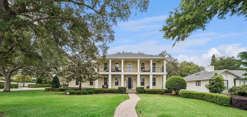 A covered patio overlooks a backyard swimming pool with a gazebo and stone pavers — 450 LAKEWOOD DRIVE, WINTER PARK, FL