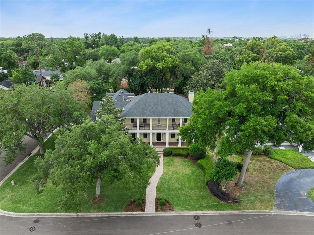 An aerial view shows a two-story house with a wrap-around porch and surrounding trees — 450 LAKEWOOD DRIVE, WINTER PARK, FL
