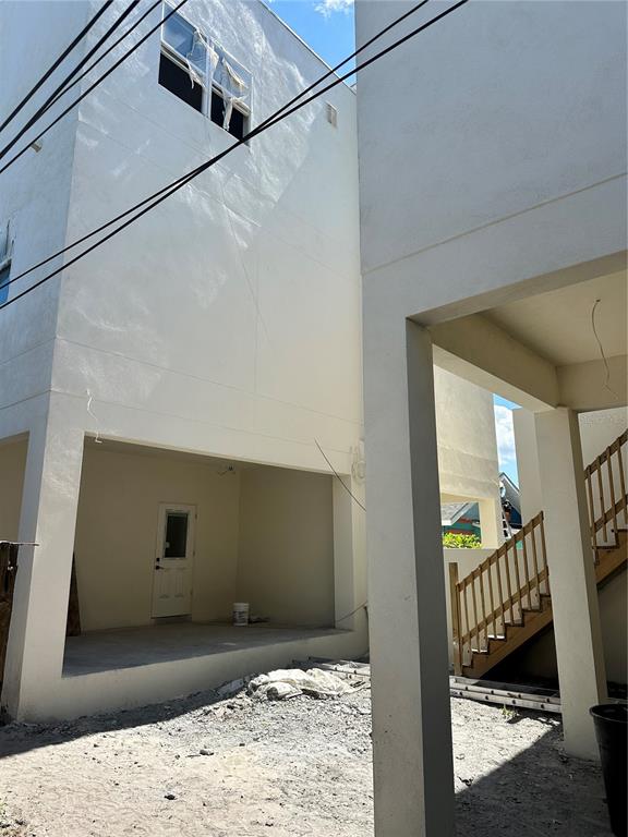 A view of the exterior ground level of a white building with an outdoor staircase — 2144 5TH AVENUE N, ST PETERSBURG, FL