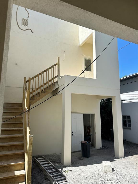 An exterior view of a two-story building featuring an outdoor wooden staircase and a doorway — 2144 5TH AVENUE N, ST PETERSBURG, FL