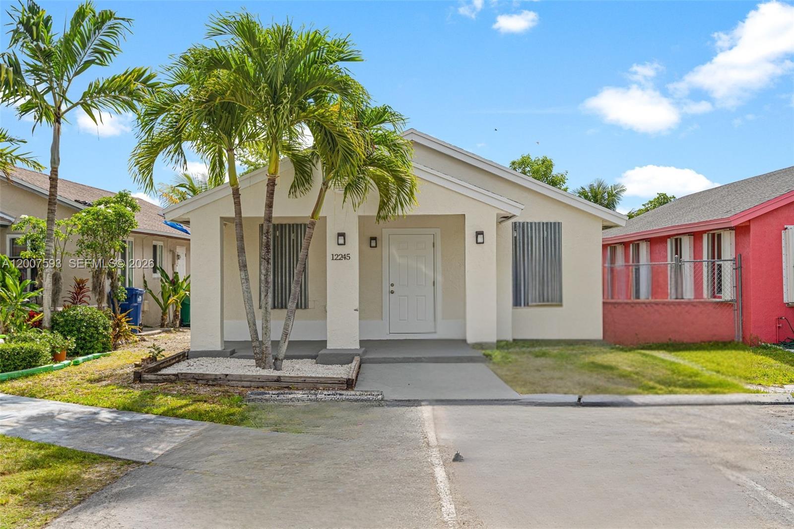 A single-story house with a beige exterior, a front porch, and palm trees — 12245 SW 201st Ter, Miami FL 33177, MIAMI, FL