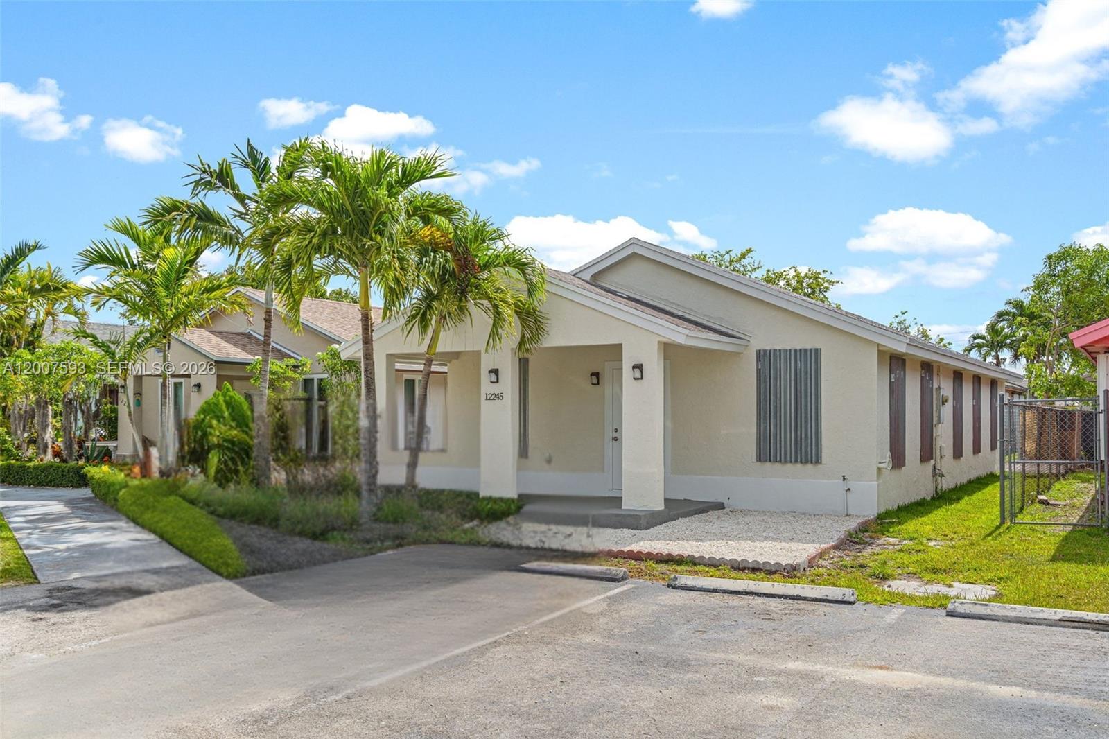 A single-story house with a covered porch, palm trees, and a paved driveway — 12245 SW 201st Ter, Miami FL 33177, MIAMI, FL