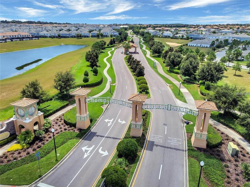 An aerial view shows the gated entrance to a residential community with a paved road — 700 WHISTLING STRAITS BOULEVARD, DAVENPORT, FL