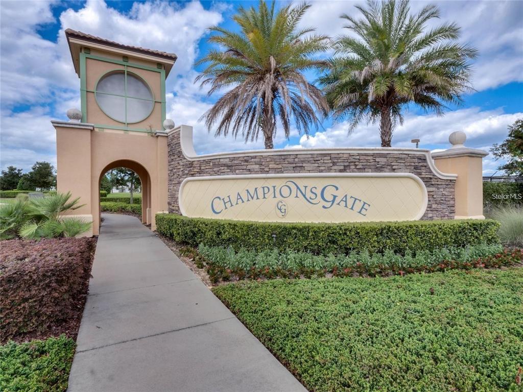 A stone and stucco monument sign for ChampionsGate stands beside a sidewalk and palm trees — 700 WHISTLING STRAITS BOULEVARD, DAVENPORT, FL