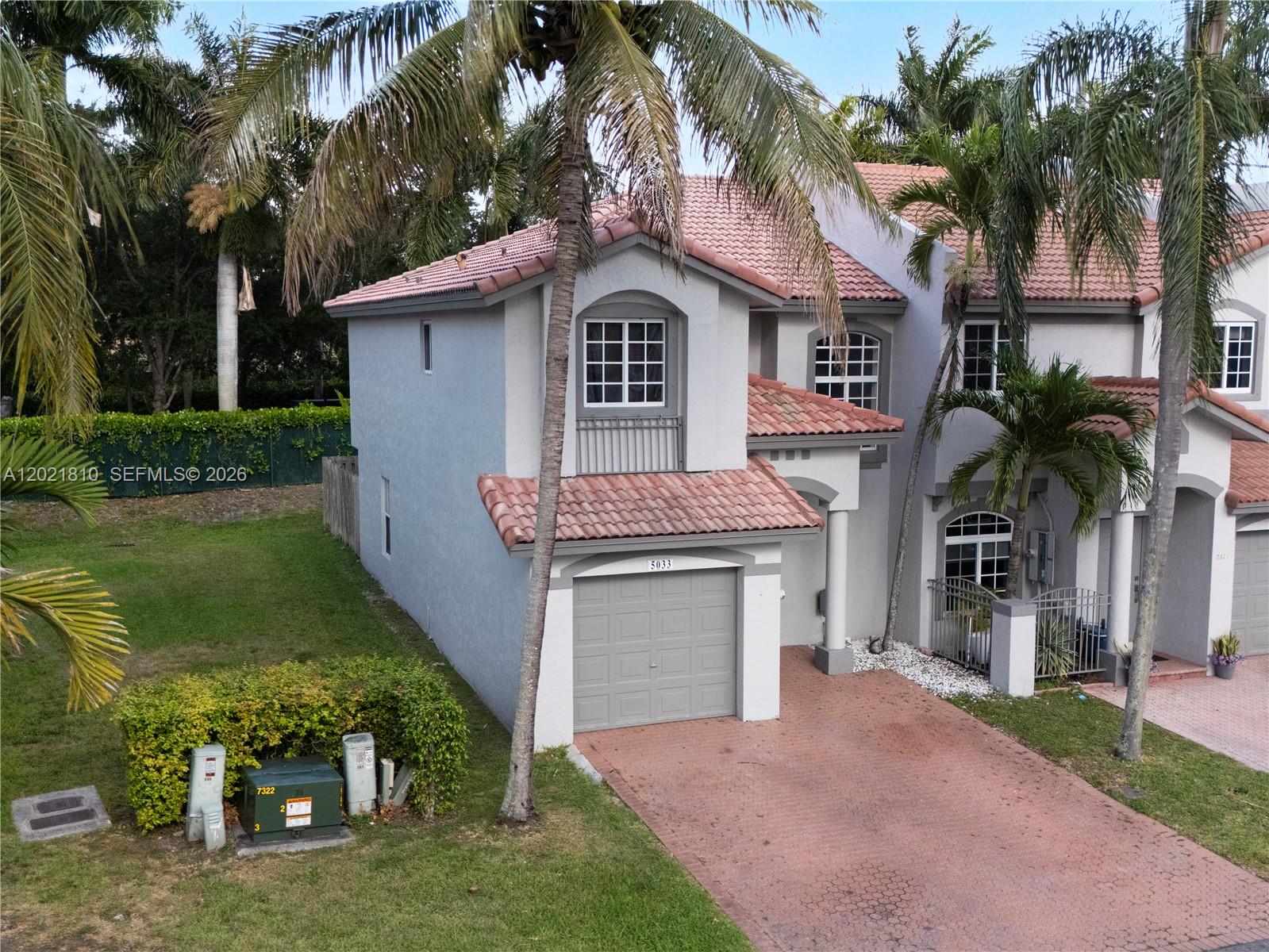 A two-story house with a garage, tiled roof, and palm trees in the front yard — 5033 NW 114th Ct, Doral FL 33178, DORAL, FL