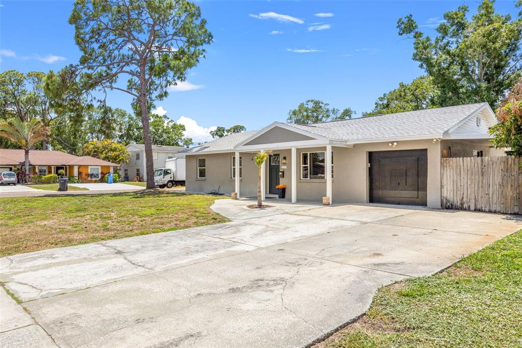 A single-story house with a concrete driveway, a dark garage door, and a covered entryway — 6802 CRESTHILL COURT, TAMPA, FL