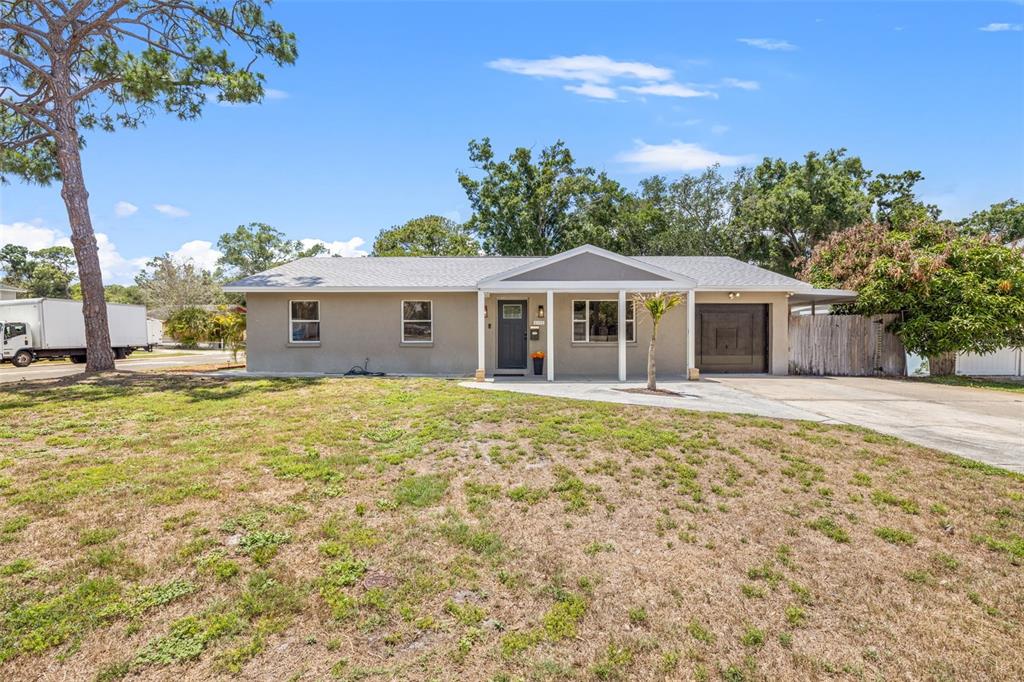 A single-story house with a gray exterior, a front porch, and a paved driveway — 6802 CRESTHILL COURT, TAMPA, FL
