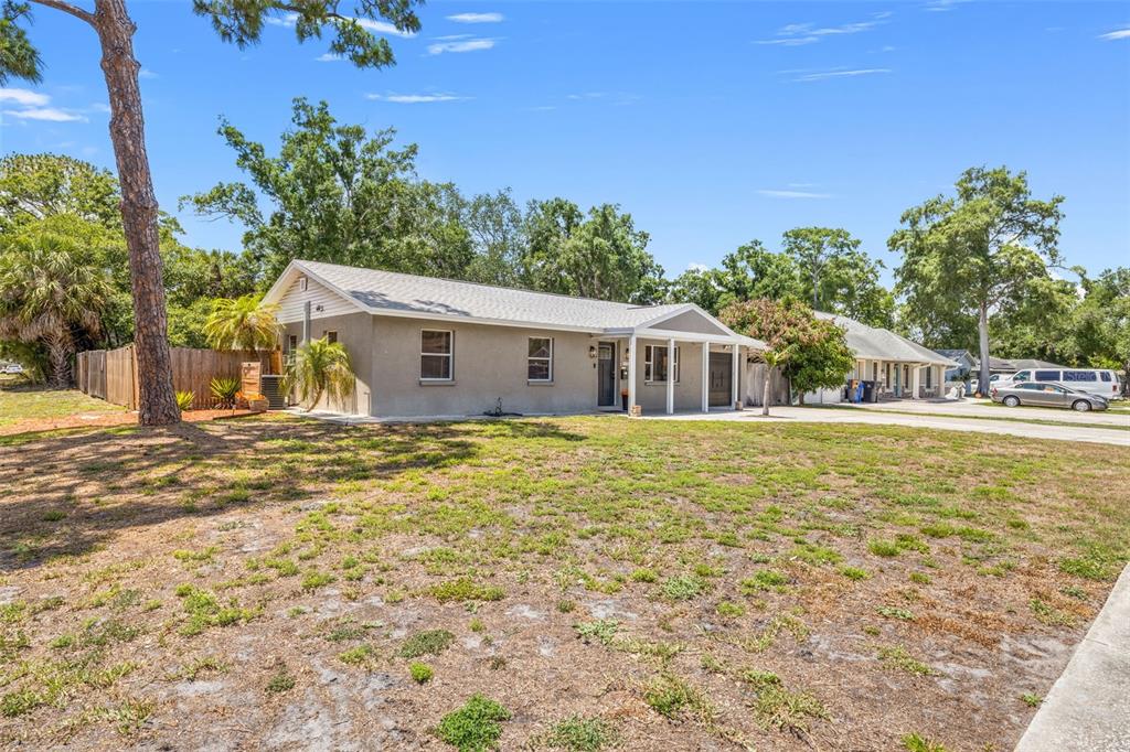 A single-story house with a gray exterior, a covered porch, and a large front yard — 6802 CRESTHILL COURT, TAMPA, FL