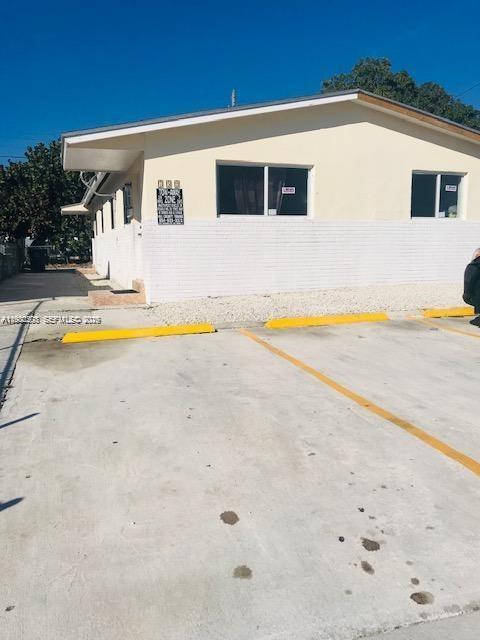 A single-story building with a white brick exterior and a concrete parking lot — 752 NW 3rd Ct, Hallandale Beach FL 33009, HALLANDALE BEACH, FL