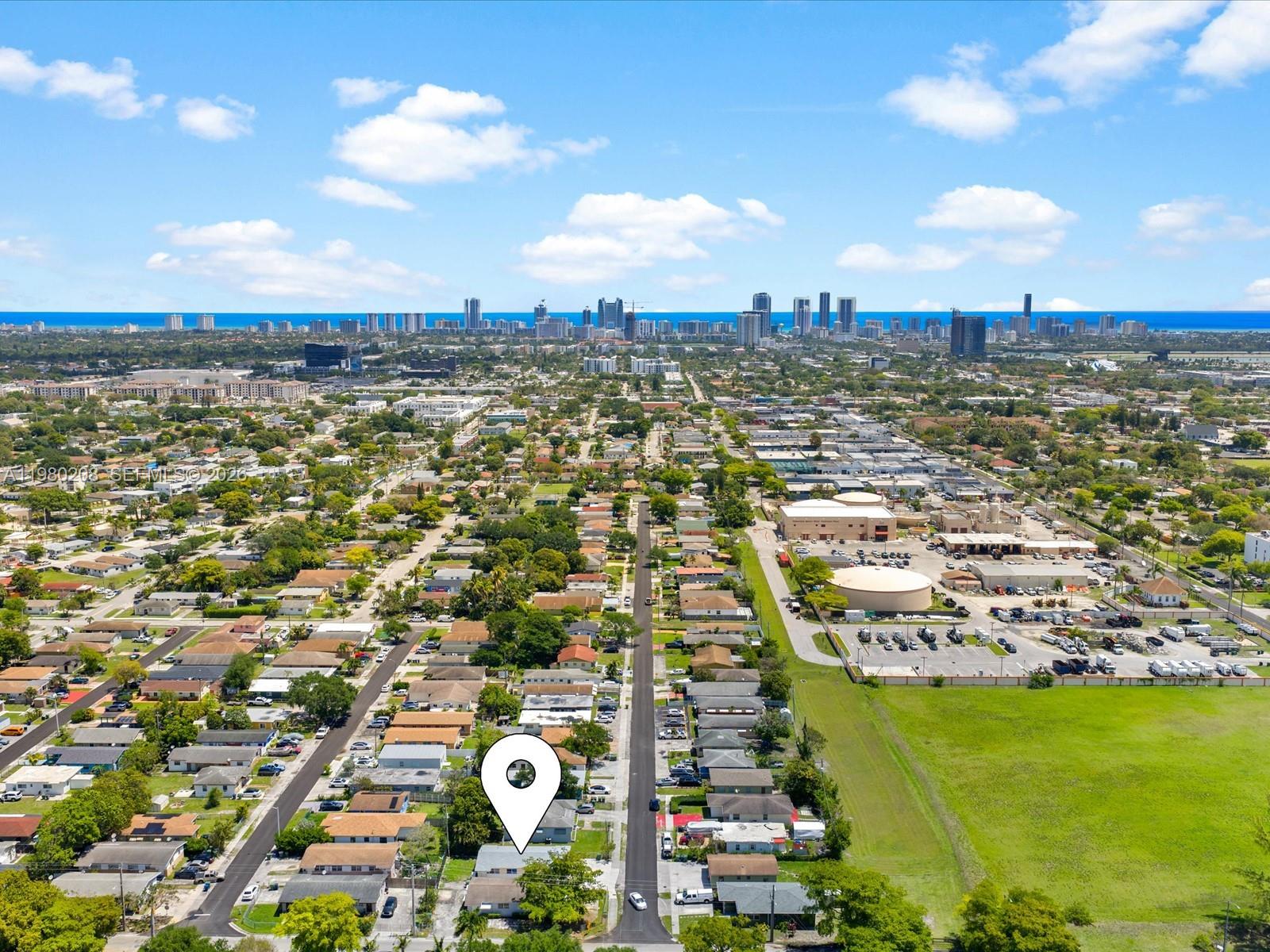 An aerial view shows a residential neighborhood with a marked house and distant city skyline — 752 NW 3rd Ct, Hallandale Beach FL 33009, HALLANDALE BEACH, FL