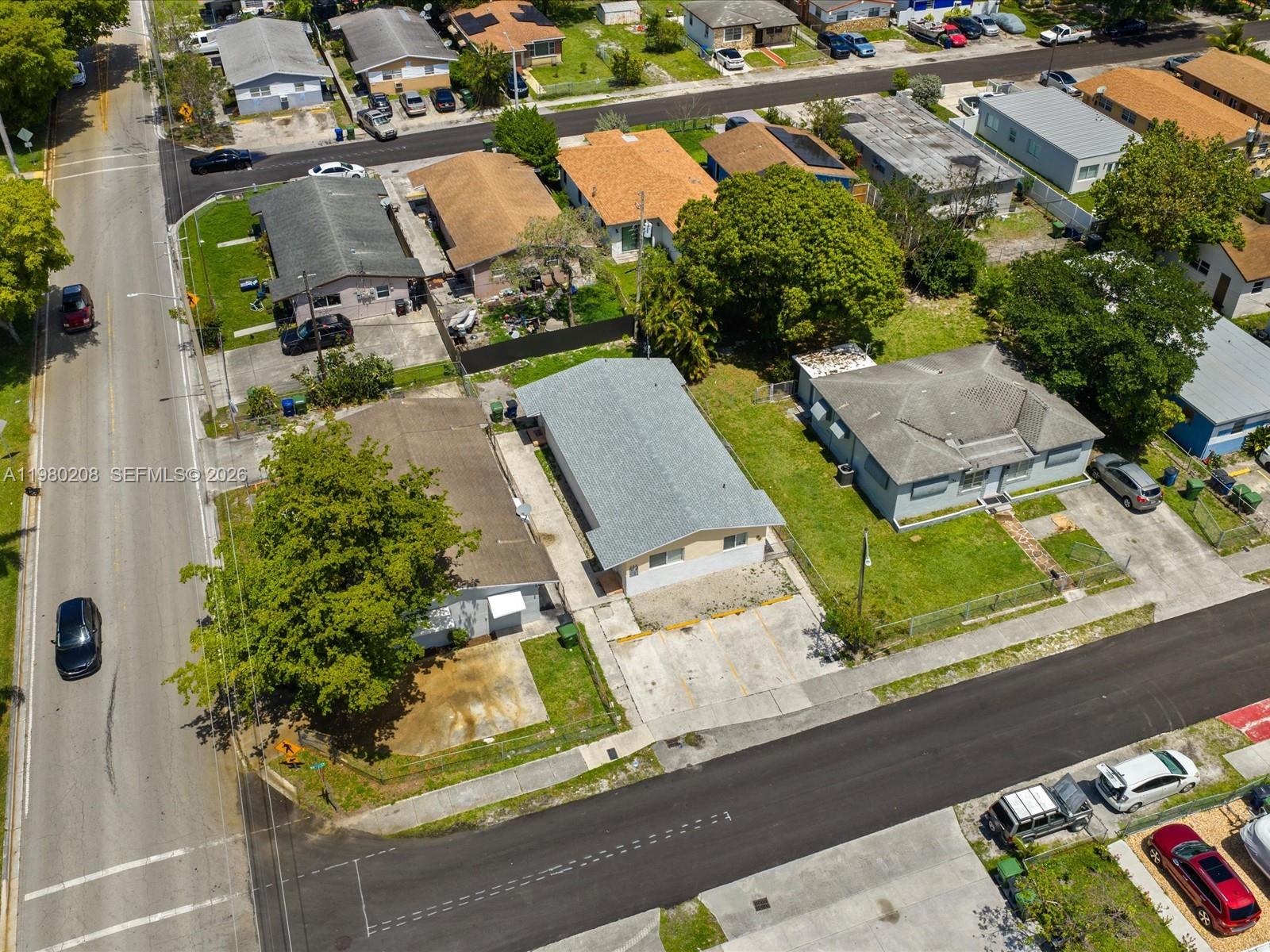 An aerial view shows several residential houses with driveways and trees along a paved street — 752 NW 3rd Ct, Hallandale Beach FL 33009, HALLANDALE BEACH, FL