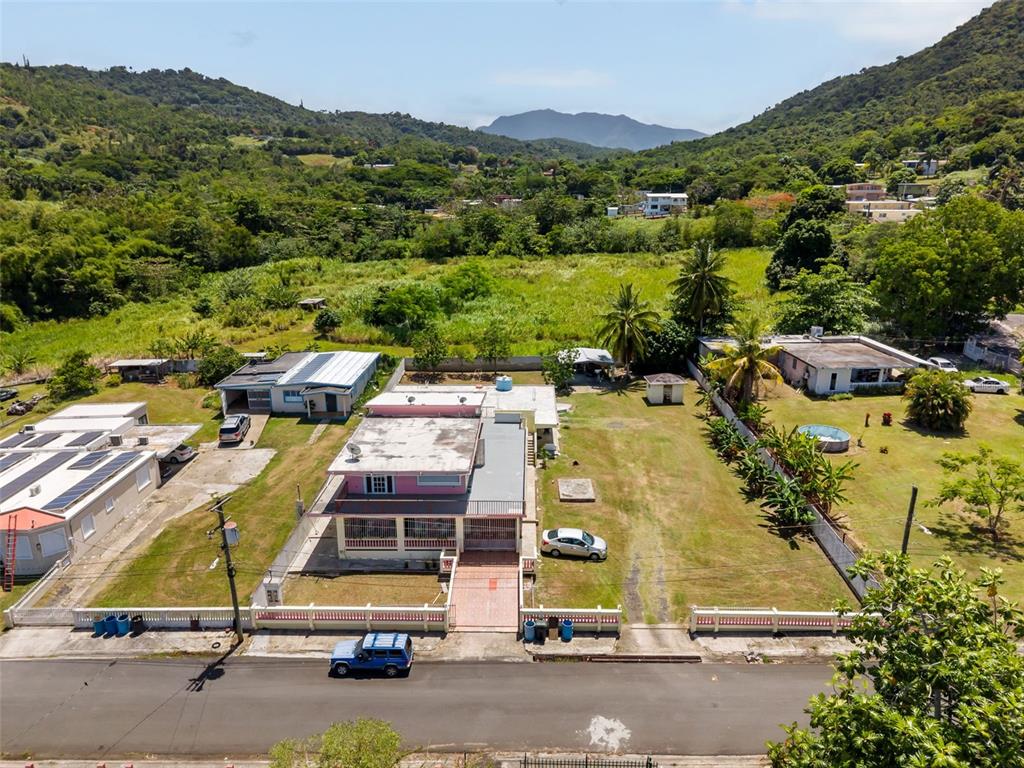 An aerial view shows a pink house with a flat roof and a large yard — . SR 975 KM.1.6 LAS CALDERONAS, CEIBA, PR