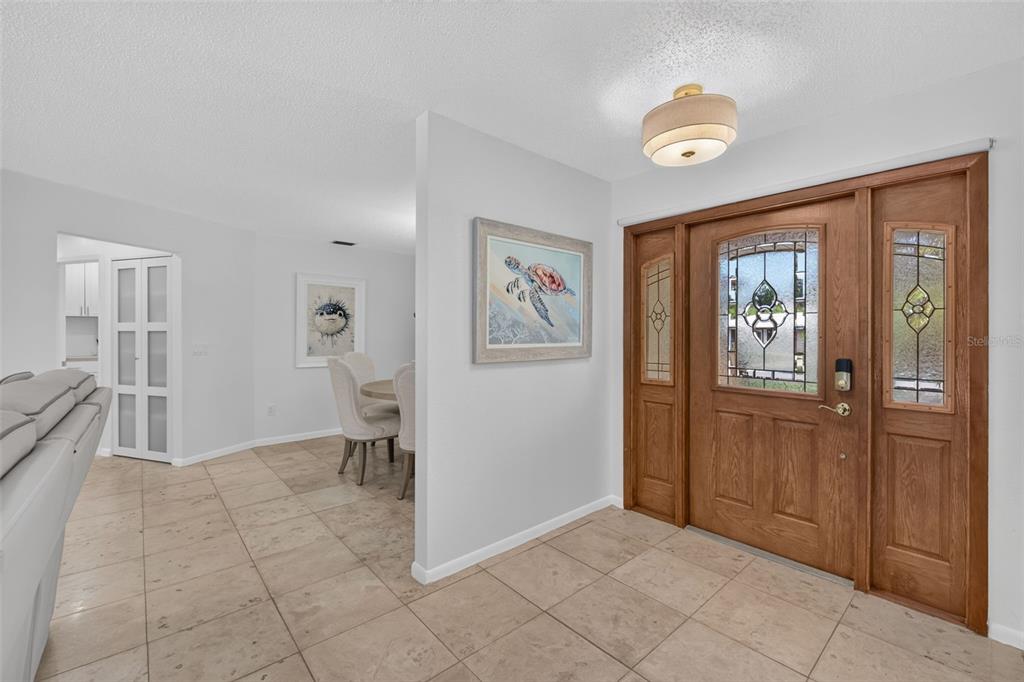 A single-story house with a tan exterior, arched decorative accents, and a brown garage door — 2199 BENDWAY DRIVE, PORT CHARLOTTE, FL