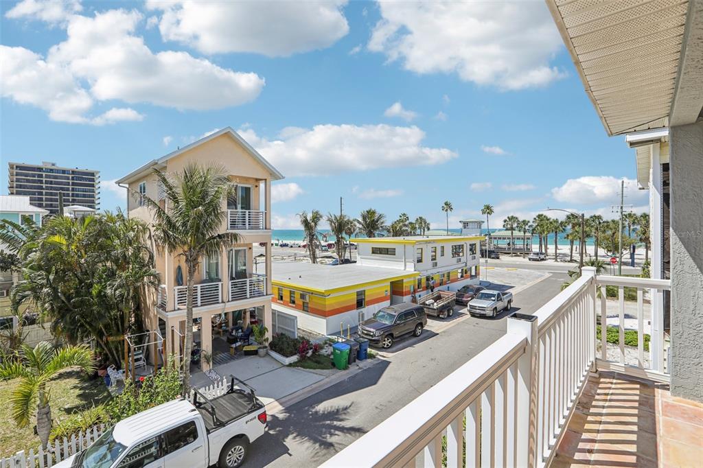 An elevated view from a balcony overlooking a street, beach houses, and the ocean — 23 80TH AVENUE, TREASURE ISLAND, FL