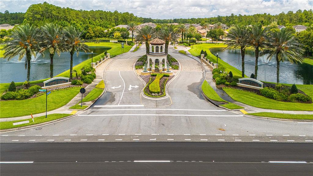 An aerial view shows the gated entrance of a residential community with palm-lined ponds — 3169 PARADOR WAY, JACKSONVILLE, FL
