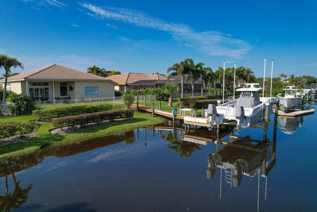 An aerial view shows a waterfront house with a boat lift and dock on a canal — 479 SW Lost River Road, Stuart FL 34997, STUART, FL