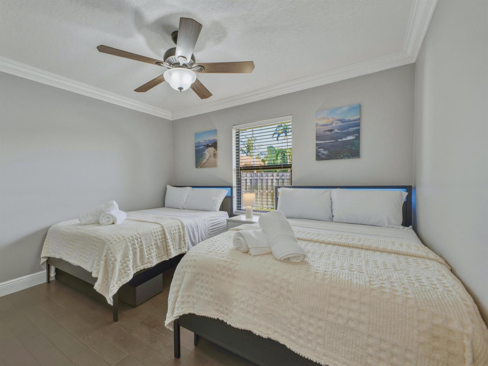 A bedroom features two beds with white bedding, a ceiling fan, and a window — 1127 Sea Pines Way, Lantana FL 33462, LANTANA, FL