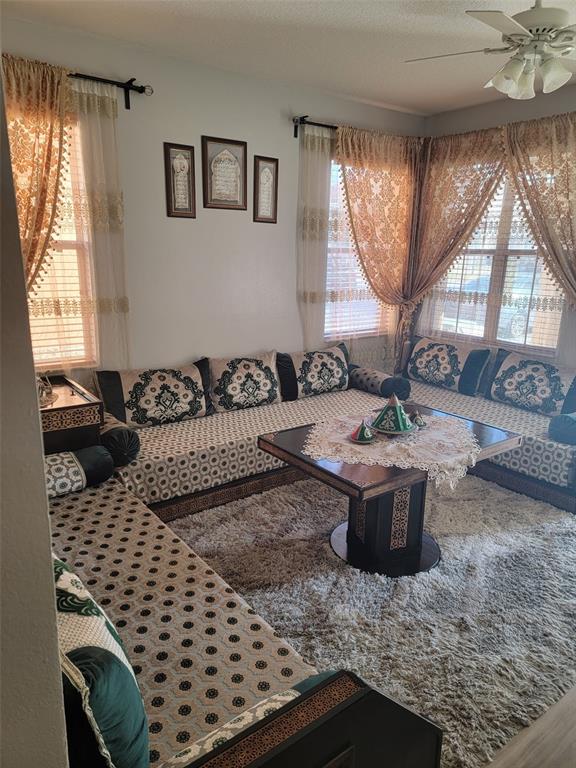 A living room features L-shaped floor seating with patterned cushions, a central table, and curtains — 2682 MAYAGUANA STREET, KISSIMMEE, FL
