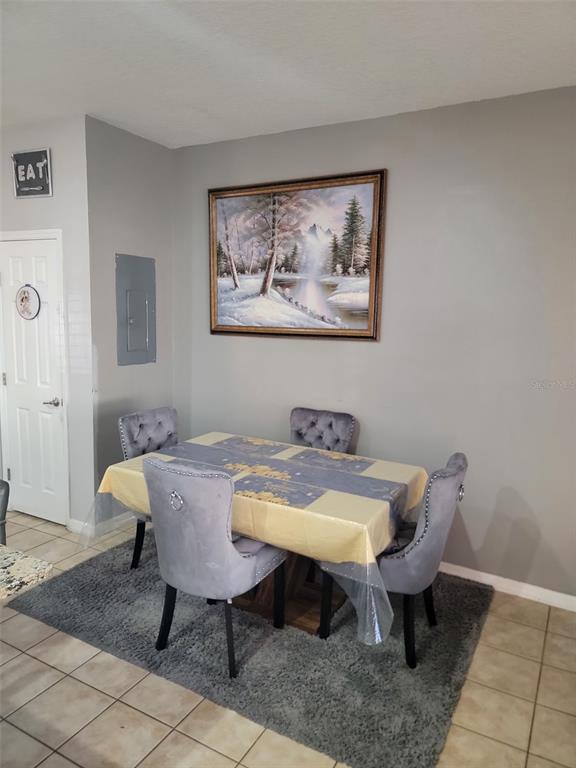 A dining area features a table with four tufted chairs on a gray rug — 2682 MAYAGUANA STREET, KISSIMMEE, FL