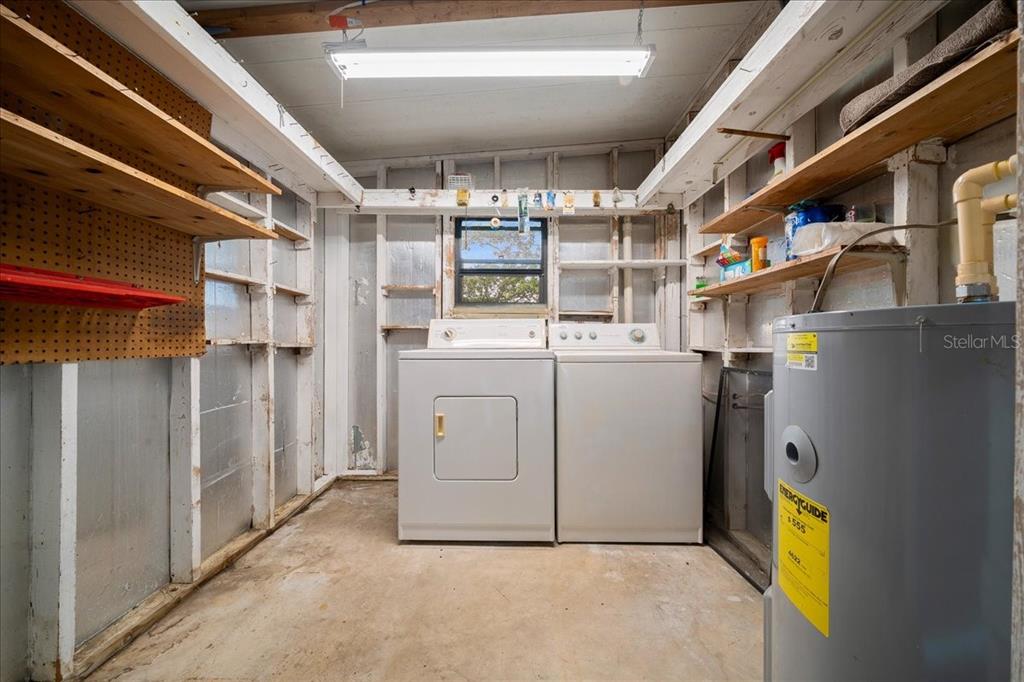 A utility room features a washer, dryer, water heater, and open wooden shelving — 9200 SW 103RD LANE, OCALA, FL