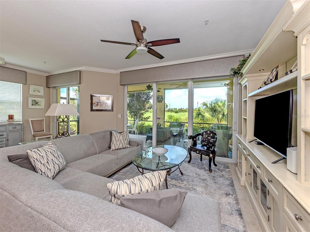 A living room features a gray sectional sofa, glass coffee table, and sliding doors to a patio — 194 BELLA VISTA TERRACE UNIT 26A, NORTH VENICE, FL