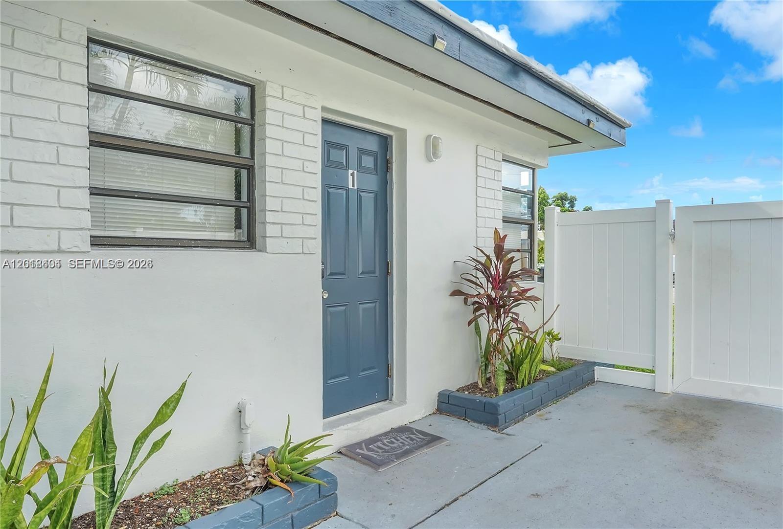 A blue front door labeled number one is set in a white exterior wall — 6036 Polk St # 1, Hollywood FL 33024, HOLLYWOOD, FL