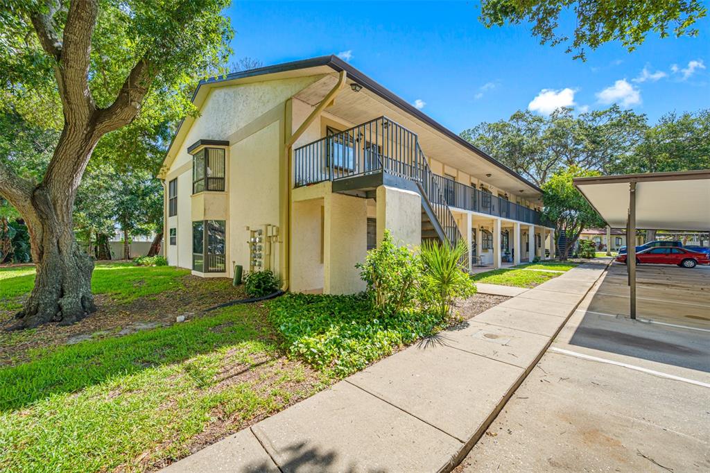 A two-story apartment building with a metal staircase, balconies, and a covered parking area — 11511 113TH STREET UNIT 10A, LARGO, FL