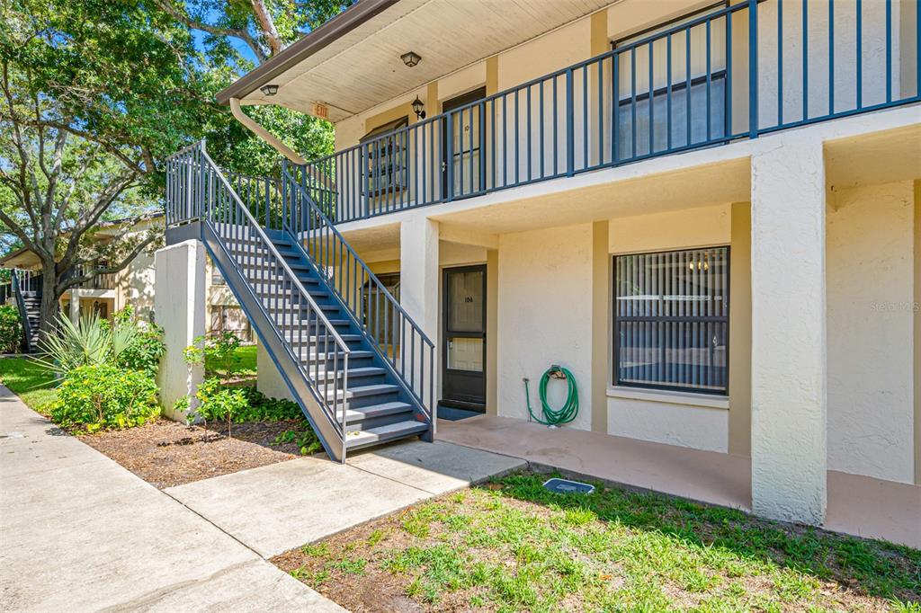 A two-story apartment building exterior features a metal staircase leading to an upper balcony — 11511 113TH STREET UNIT 10A, LARGO, FL