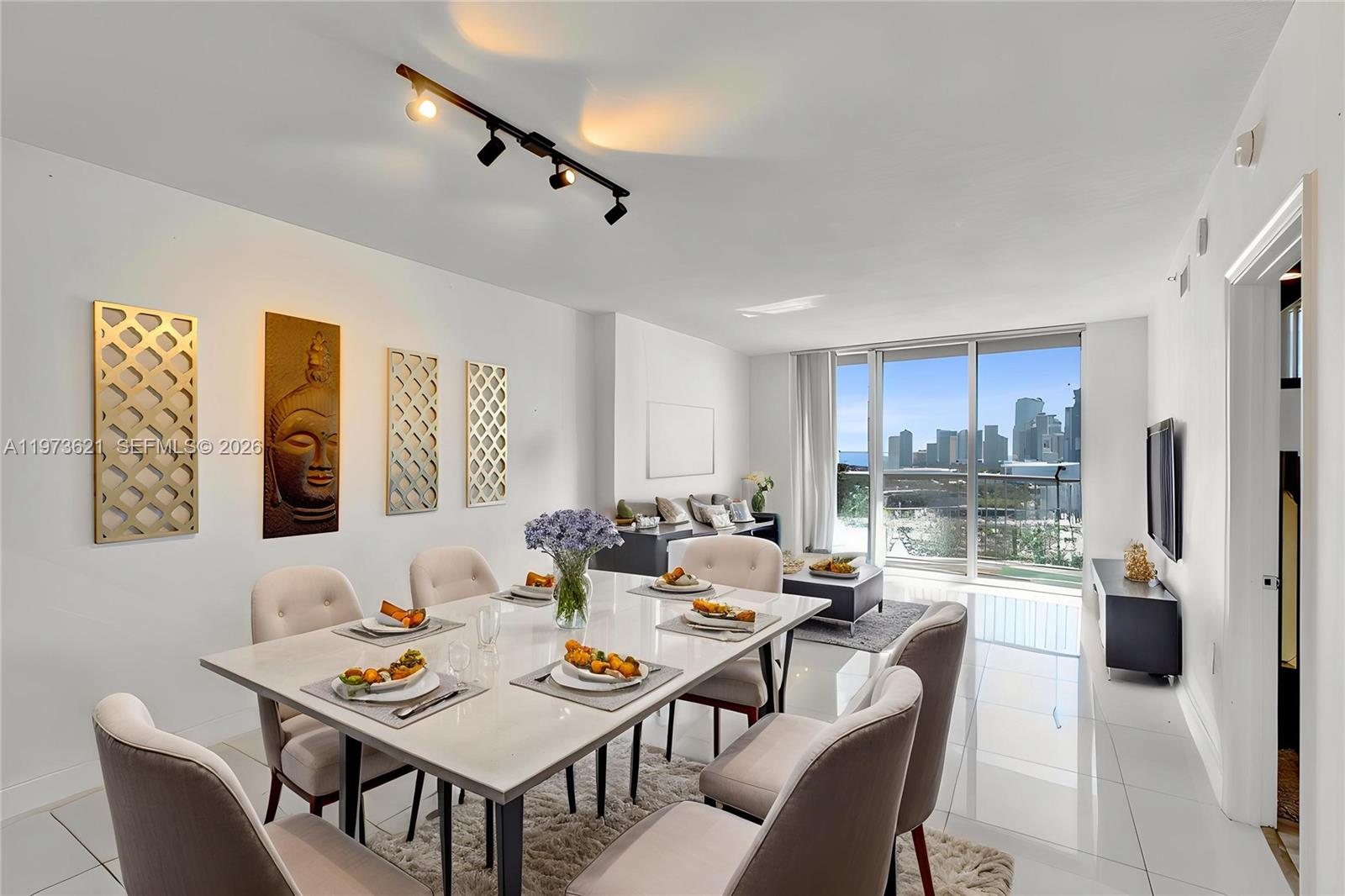 A dining area with a white table and chairs sits before a balcony with city views — 1750 N Bayshore Dr # 2510, Miami FL 33132, MIAMI, FL