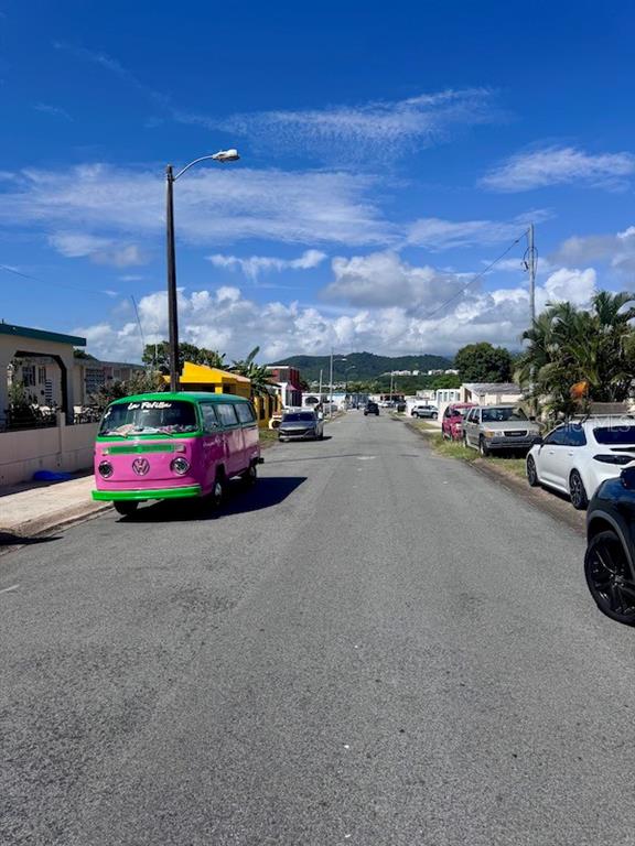 A street view shows a pink and green Volkswagen bus parked on a residential road — Vistas Del Convento CALLE 3, FAJARDO, PR