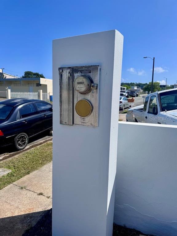 An outdoor electric meter is mounted on a white concrete pillar near a street — Vistas Del Convento CALLE 3, FAJARDO, PR