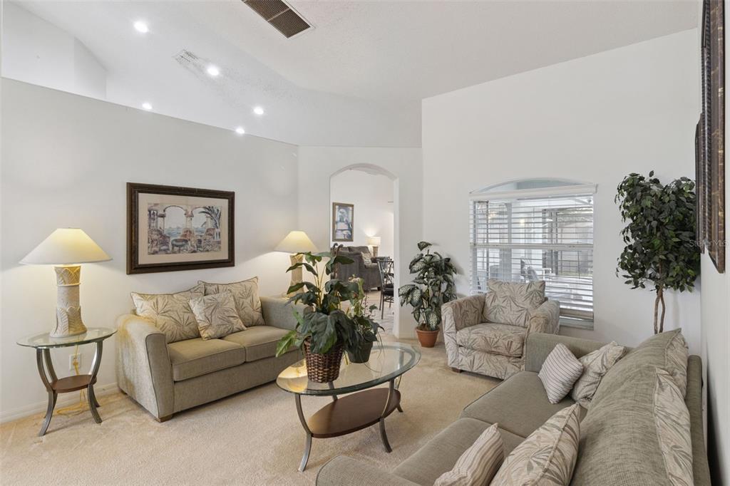 A living room features two sofas, a glass coffee table, and a window with blinds — 3144 IBIS HILL STREET, CLERMONT, FL