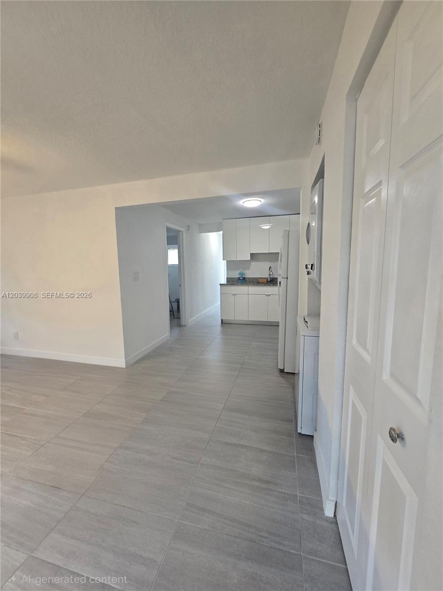 A view of a kitchen with white cabinets and gray tile flooring — 237 SW 13th St # 5, Dania Beach FL 33004, DANIA BEACH, FL