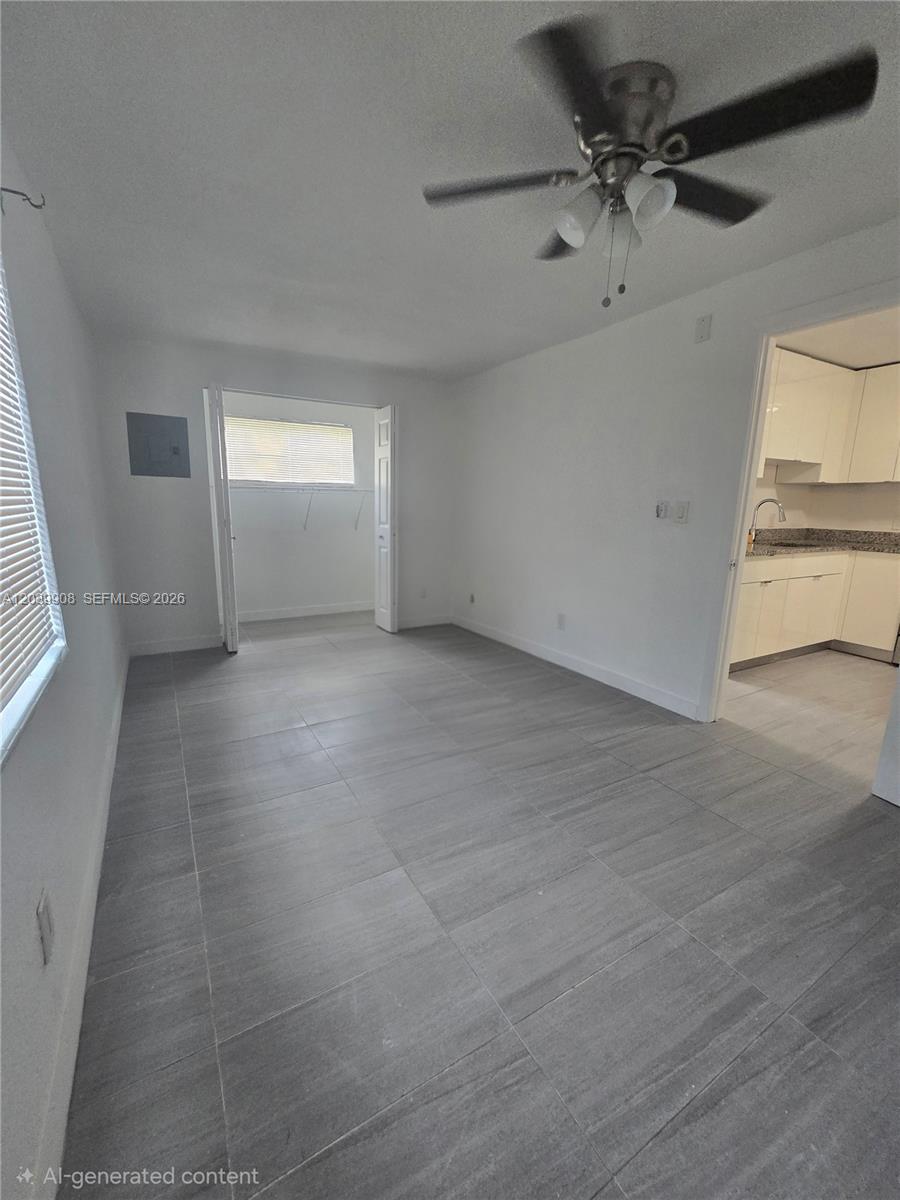 A room with gray tile flooring, a ceiling fan, and an open doorway to a kitchen — 237 SW 13th St # 5, Dania Beach FL 33004, DANIA BEACH, FL