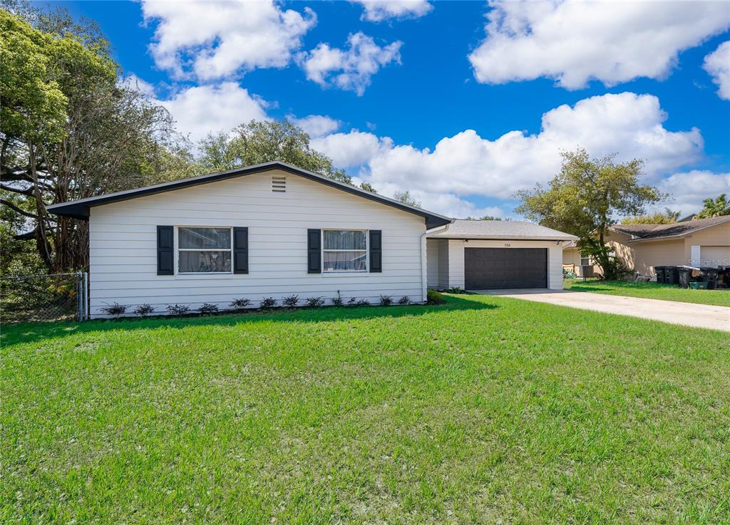 A single-story house with white siding, black shutters, and an attached two-car garage — 1914 BONANZA COURT, WINTER PARK, FL