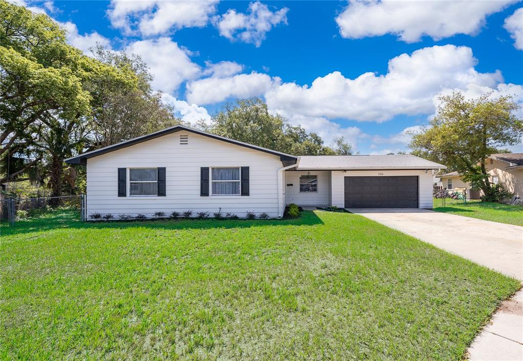 A single-story house with white siding, black shutters, and an attached two-car garage — 1914 BONANZA COURT, WINTER PARK, FL