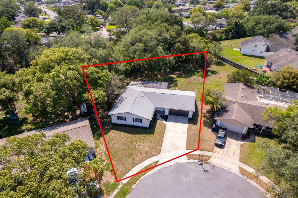 An aerial view shows a single-story house with a gray roof and driveway — 1914 BONANZA COURT, WINTER PARK, FL
