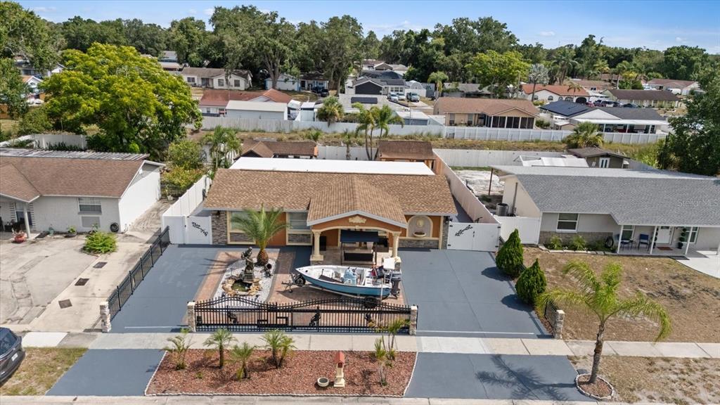 An aerial view shows a single-story house with a boat parked in the front driveway — 8318 DRYCREEK DRIVE, TAMPA, FL