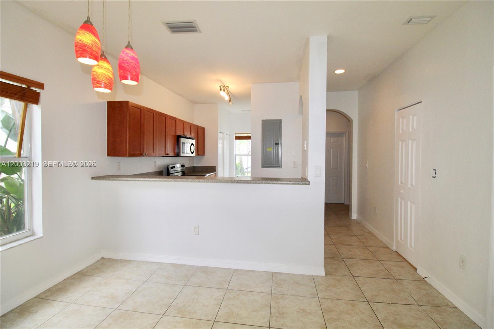 A kitchen with wood cabinets and a breakfast bar overlooks a tiled dining area — 14054 SW 49th St # 20, Miramar FL 33027, MIRAMAR, FL