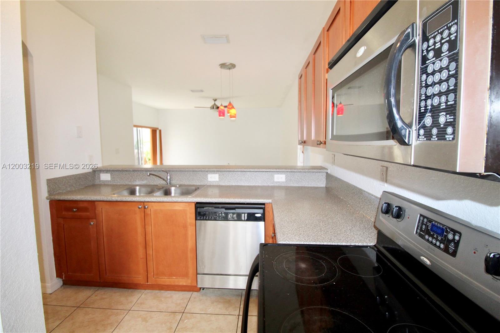 A kitchen features wood cabinets, stainless steel appliances, and a gray countertop with a sink — 14054 SW 49th St # 20, Miramar FL 33027, MIRAMAR, FL