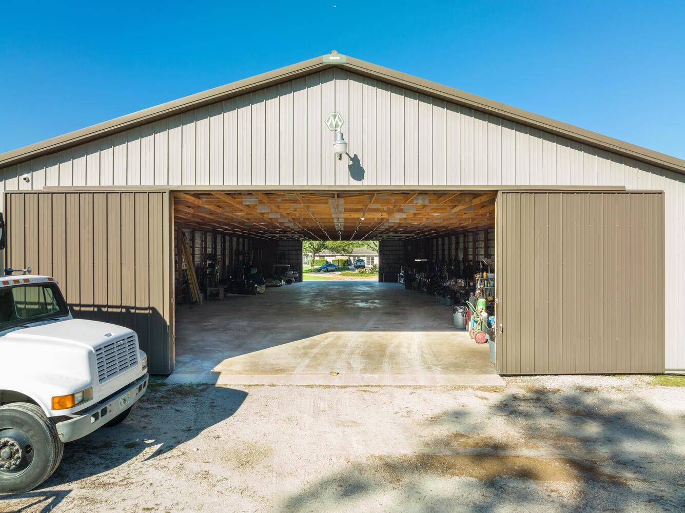 A large metal barn with open sliding doors and a white truck parked outside — 13528 N 6th Court N, FL 33470, FL