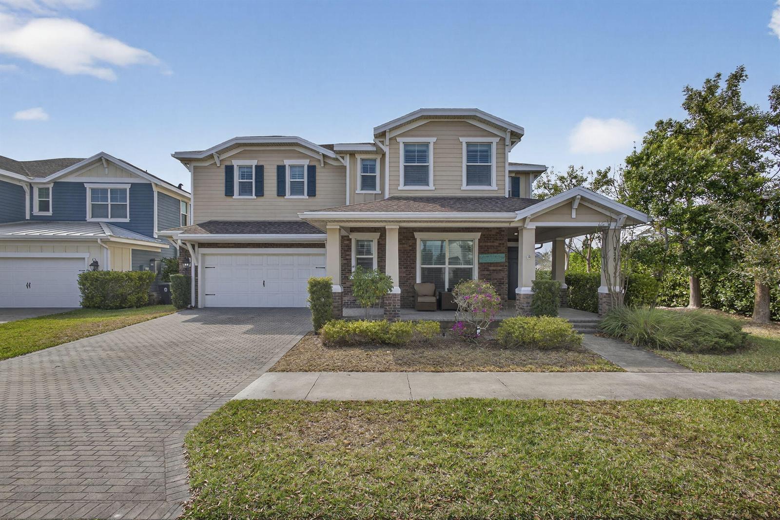 A two-story house with a brick and siding exterior, a front porch, and a garage — 929 Sterling Pine Place, FL 33470, FL