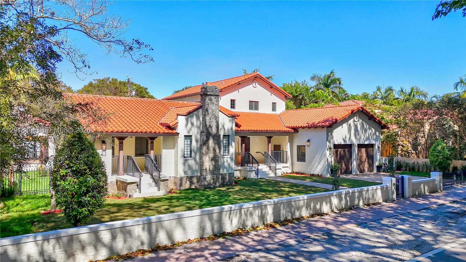 A single-story house with a red tile roof, stone chimney, and attached two-car garage — 519 Alhambra Cir, Coral Gables FL 33134, CORAL GABLES, FL